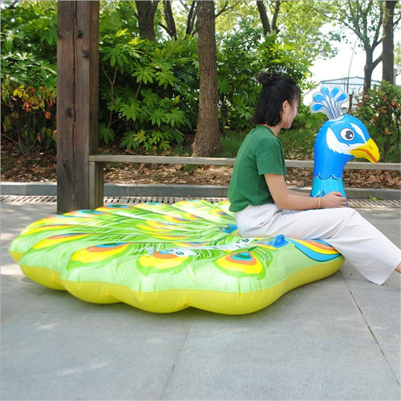 A Peacock Floats An Inflatable Toy On The Water